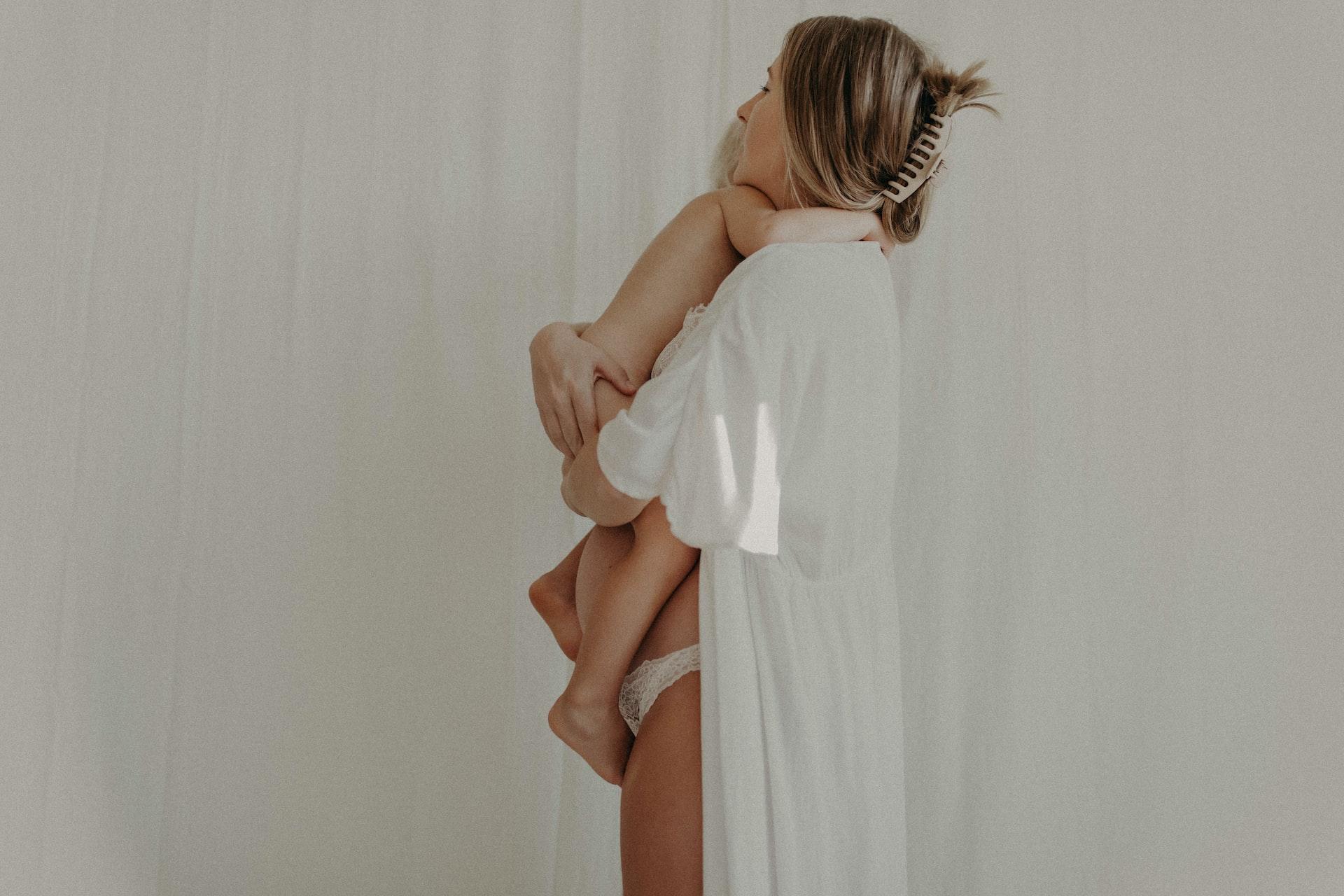 a woman in a white dress holding a child